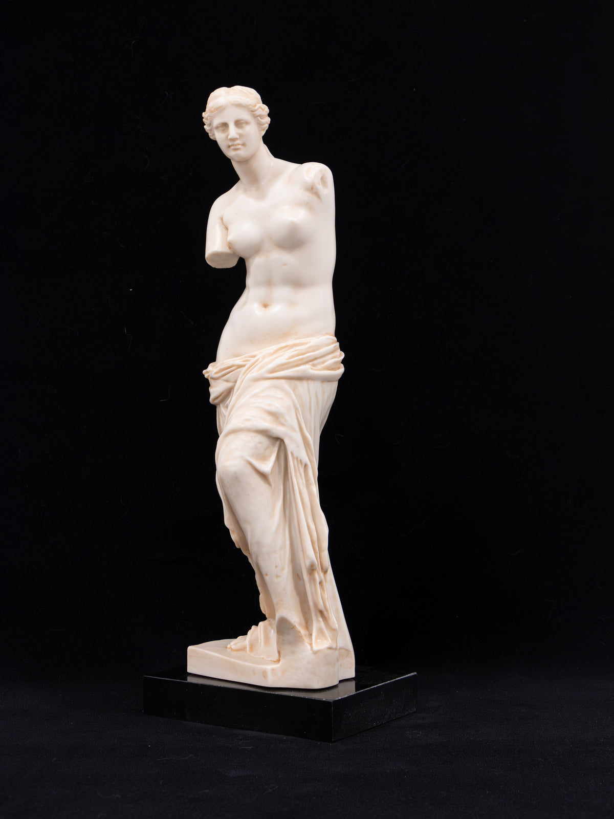 Estatua de la Venus de Milo sobre peana negra, arte helenístico, vista frontal