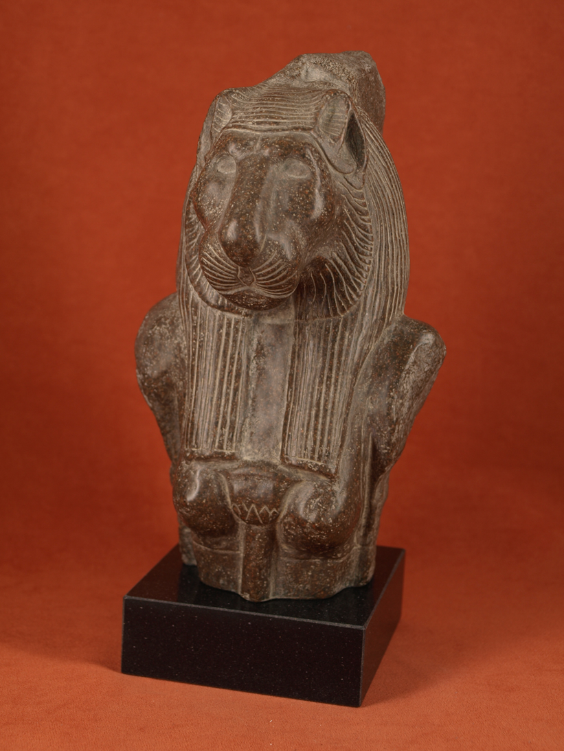 escultura de la diosa egipcia con cabeza de leona en piedra oscura
