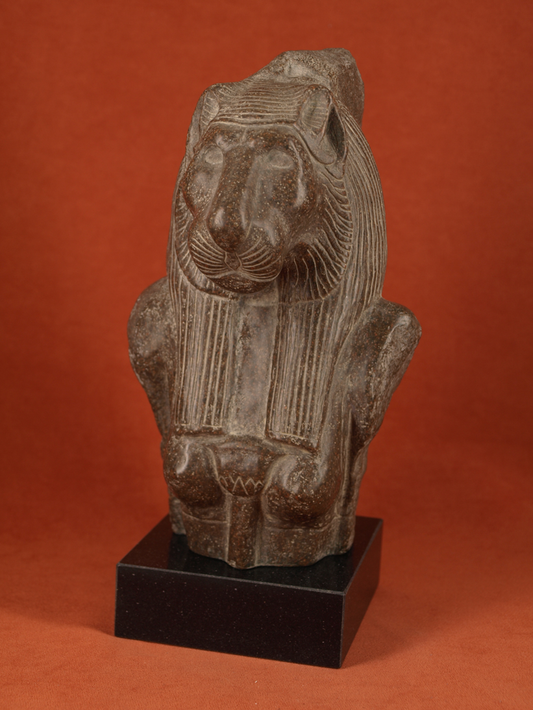 escultura de la diosa egipcia con cabeza de leona en piedra oscura